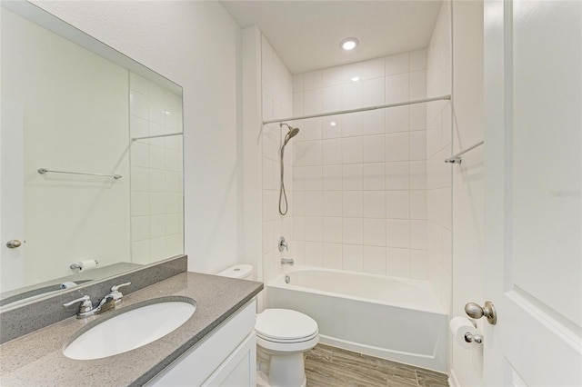 bathroom with vanity, washtub / shower combination, toilet, and wood finished floors