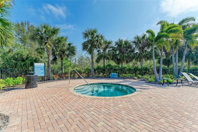 view of swimming pool featuring a patio area, a hot tub, and fence