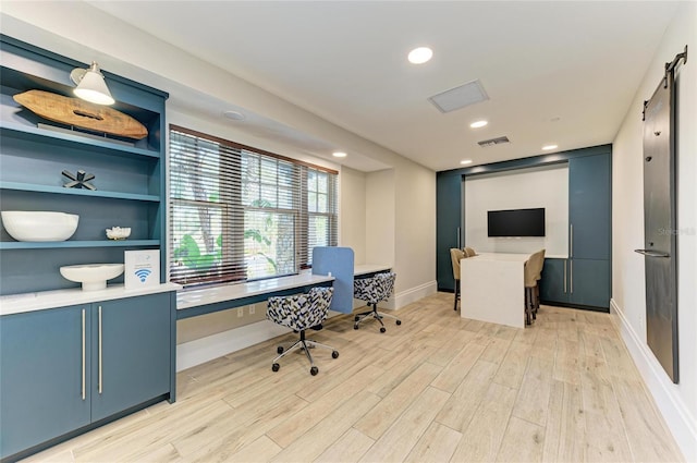 office area with visible vents, baseboards, recessed lighting, a barn door, and light wood-type flooring