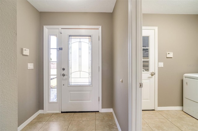 tiled entryway with washer / dryer