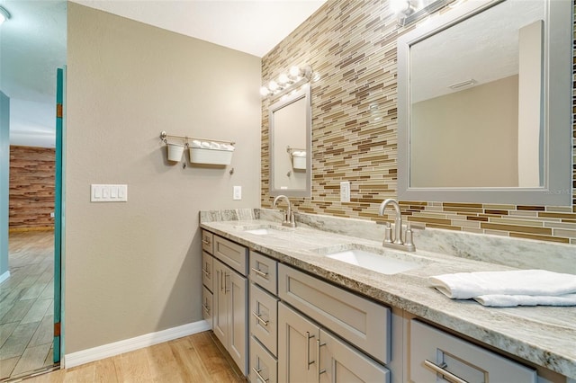 bathroom featuring vanity, hardwood / wood-style floors, and backsplash