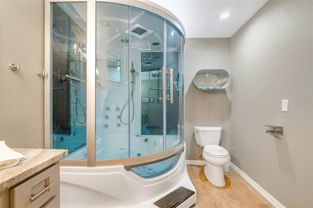 full bathroom with vanity, hardwood / wood-style floors, combined bath / shower with glass door, and toilet