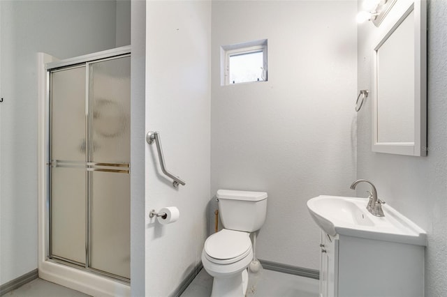 bathroom with vanity, toilet, and a shower with door