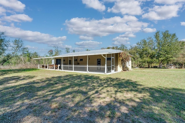 back of house with a yard and a sunroom