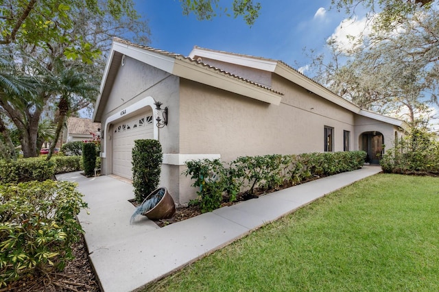 view of side of home with a garage and a yard