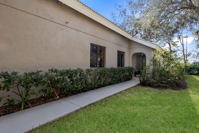 view of side of home with a yard