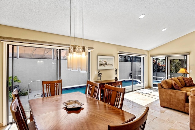 dining area with vaulted ceiling and a textured ceiling