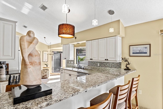 kitchen with pendant lighting, sink, and white cabinets