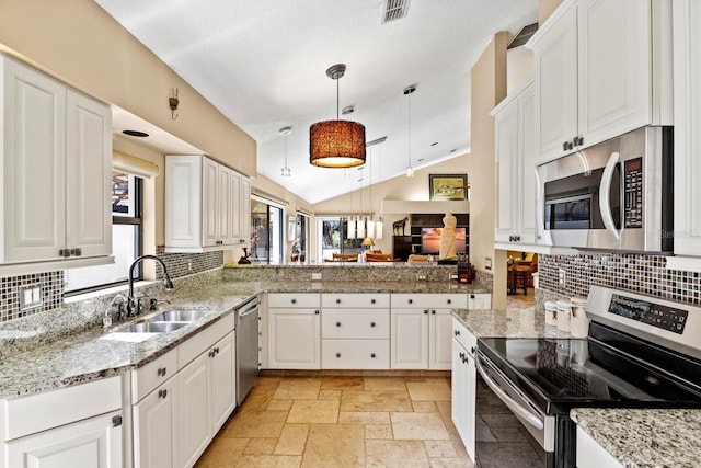 kitchen with lofted ceiling, sink, decorative light fixtures, appliances with stainless steel finishes, and white cabinets