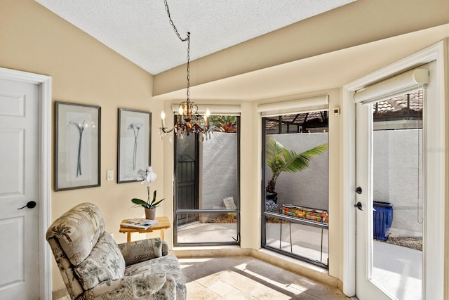 doorway to outside with lofted ceiling, a textured ceiling, and an inviting chandelier