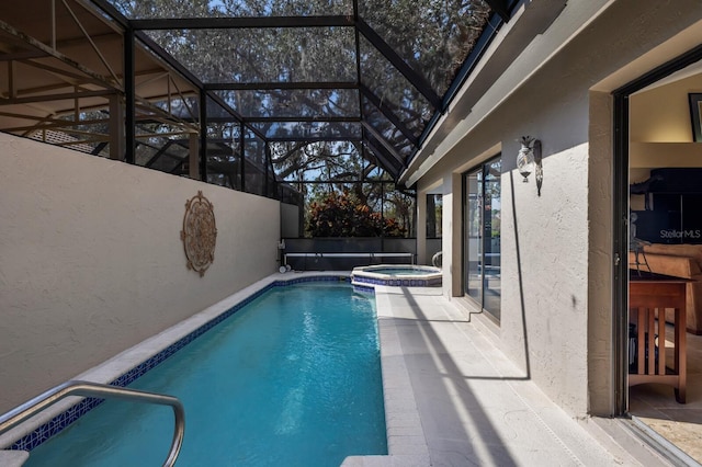 view of swimming pool with a patio, glass enclosure, and an in ground hot tub