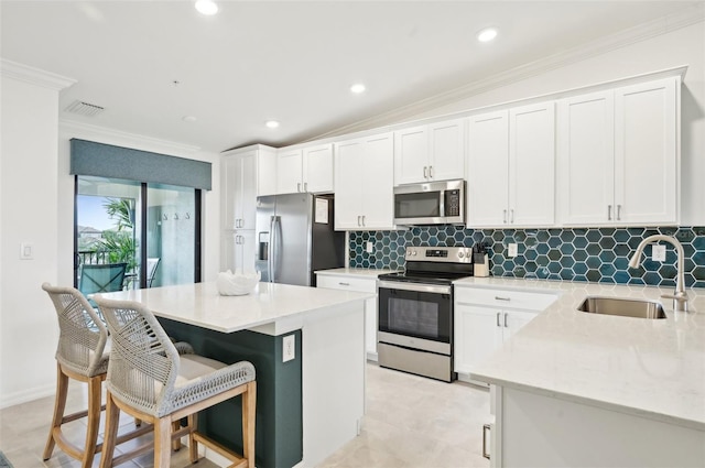 kitchen featuring stainless steel appliances, sink, and white cabinets