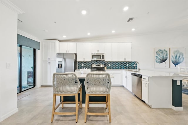 kitchen featuring sink, crown molding, appliances with stainless steel finishes, white cabinets, and backsplash