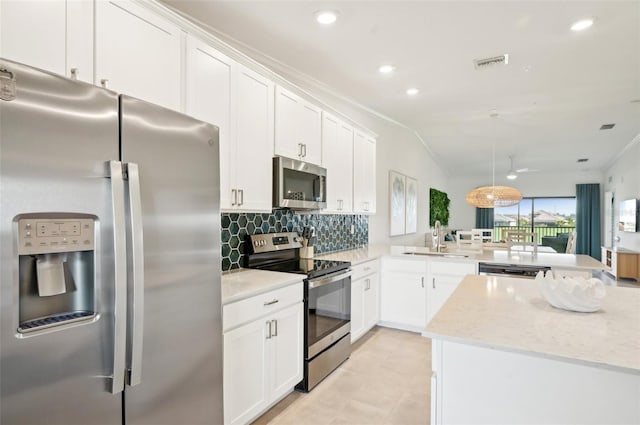 kitchen with pendant lighting, sink, appliances with stainless steel finishes, white cabinetry, and kitchen peninsula