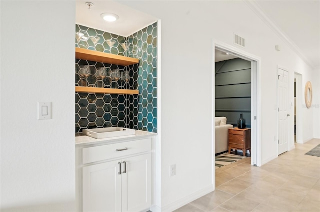 bar featuring crown molding and white cabinets