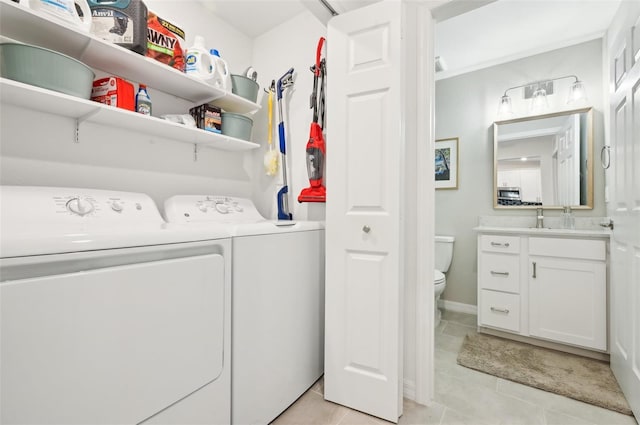 clothes washing area featuring light tile patterned flooring, sink, and washer and clothes dryer