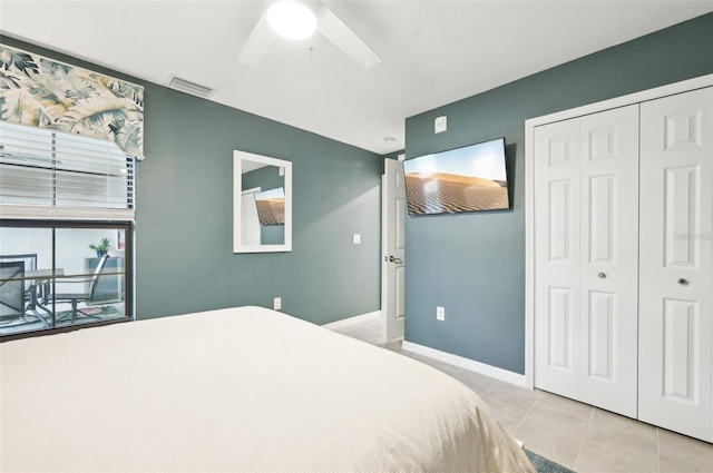 tiled bedroom with ceiling fan and a closet