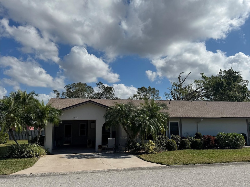 ranch-style house with a front lawn and a carport