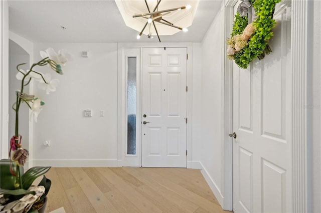 foyer entrance featuring an inviting chandelier and light hardwood / wood-style flooring