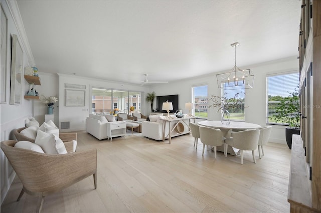 living room featuring a notable chandelier, crown molding, and light hardwood / wood-style floors