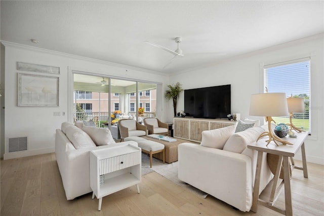 living room featuring crown molding, ceiling fan, and light hardwood / wood-style flooring