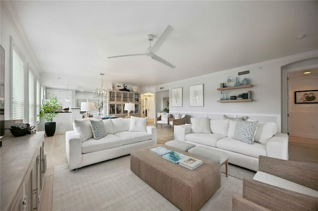 living room featuring crown molding, ceiling fan with notable chandelier, and light hardwood / wood-style flooring