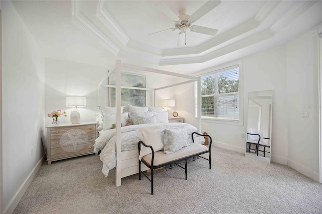 bedroom featuring ornamental molding, light colored carpet, ceiling fan, and a tray ceiling