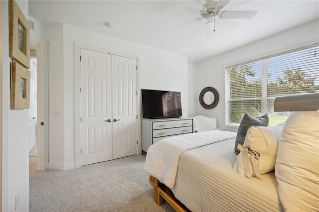 bedroom featuring ceiling fan, light colored carpet, and a closet