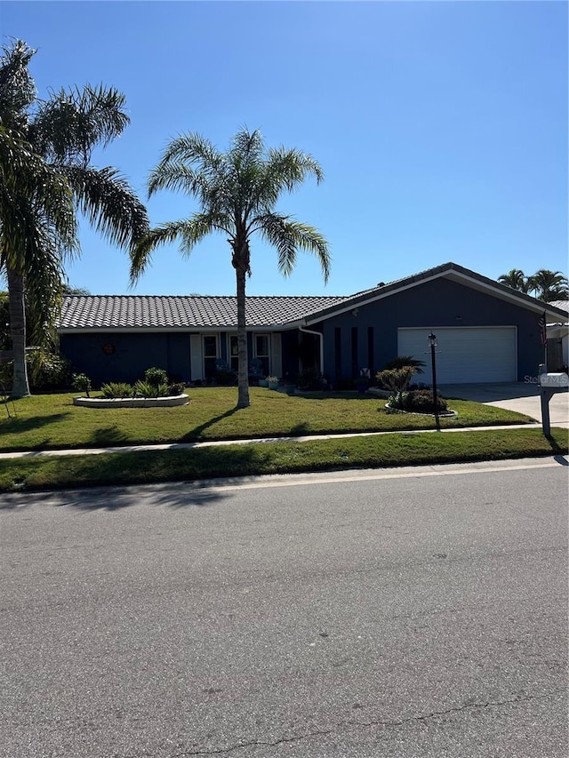 single story home featuring a garage and a front lawn