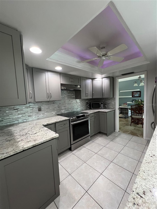 kitchen with gray cabinets, stainless steel electric stove, and a raised ceiling