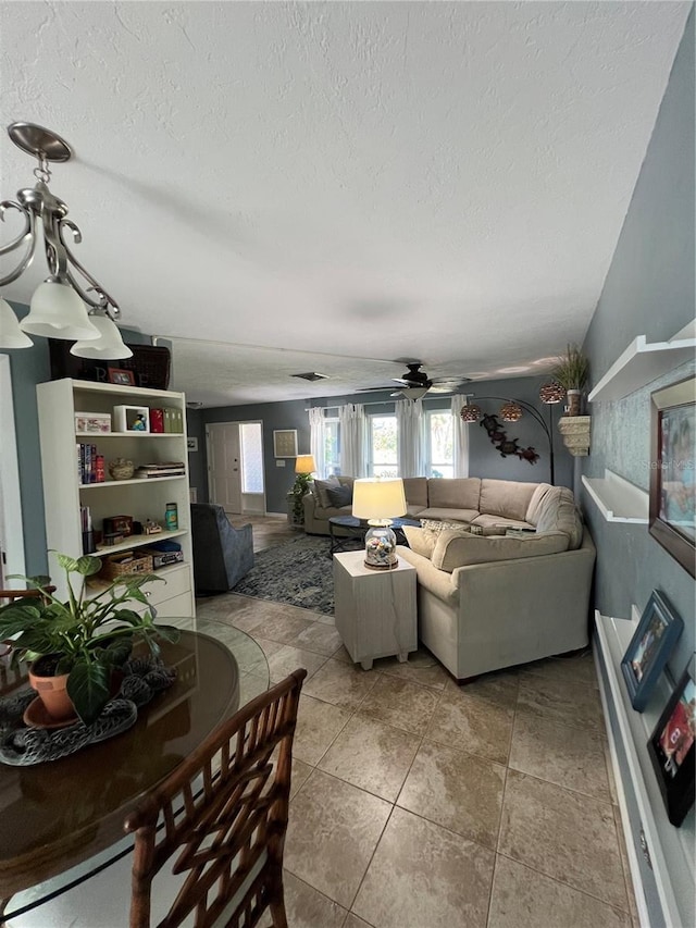 living room featuring ceiling fan and a textured ceiling