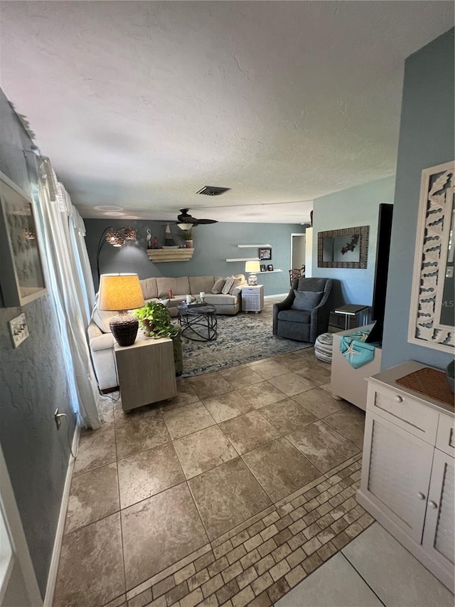 living room with a textured ceiling and ceiling fan