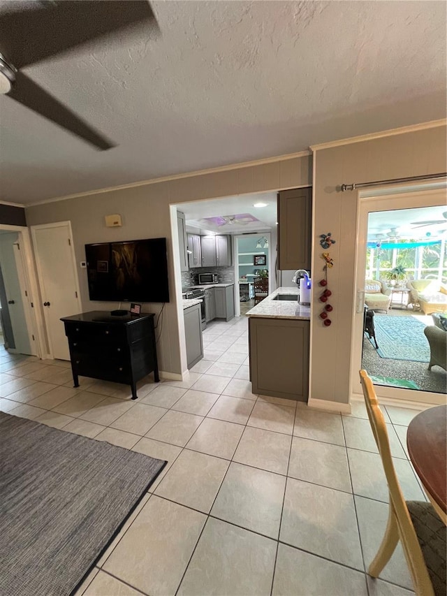 kitchen with crown molding, sink, and light tile patterned floors