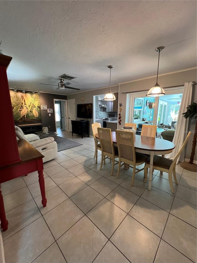 tiled dining room with crown molding and a textured ceiling