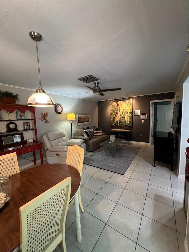 tiled dining room featuring crown molding and ceiling fan