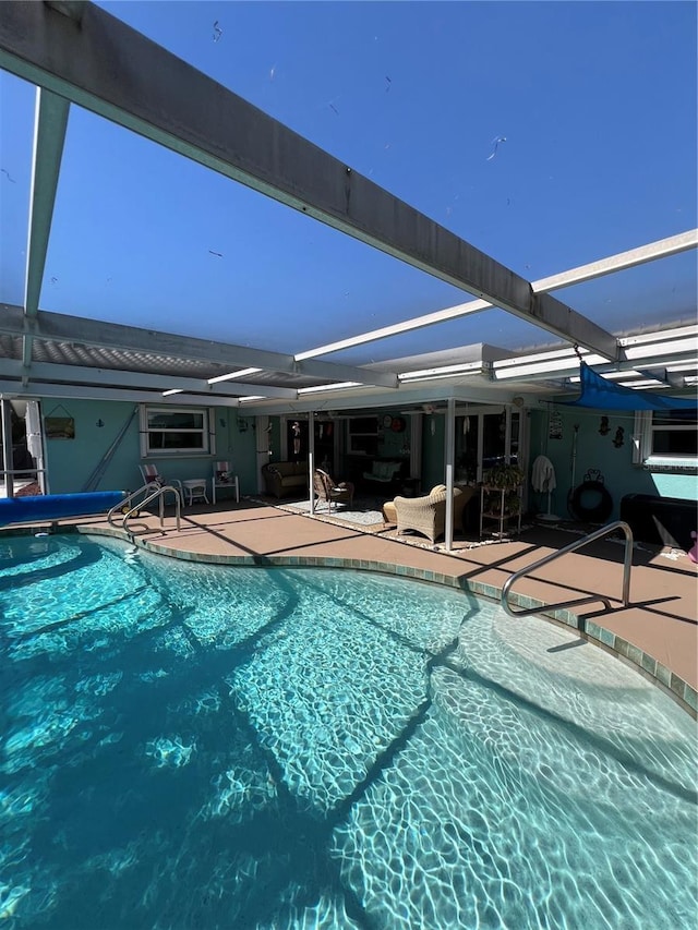 view of swimming pool featuring glass enclosure and a patio area