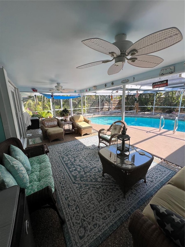 view of swimming pool featuring an outdoor living space, a lanai, ceiling fan, and a patio area