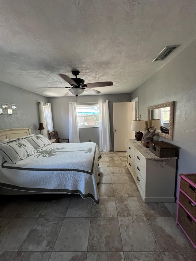 bedroom featuring ceiling fan and a textured ceiling