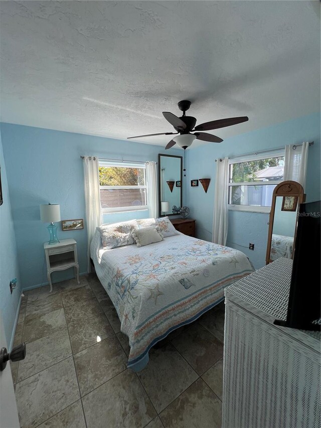 bedroom featuring ceiling fan and a textured ceiling