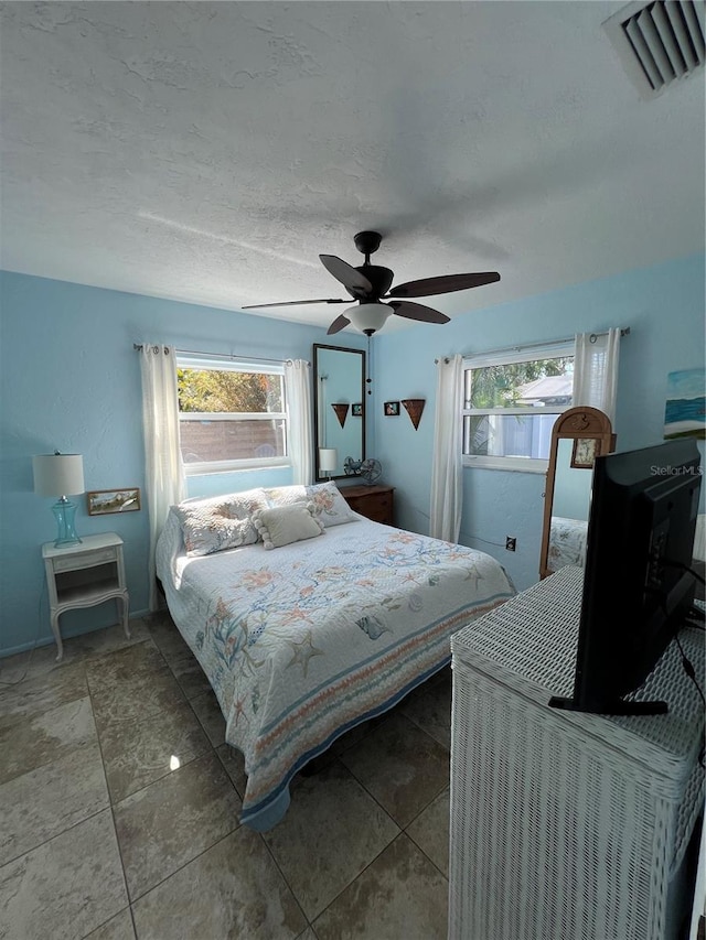 bedroom featuring ceiling fan and a textured ceiling