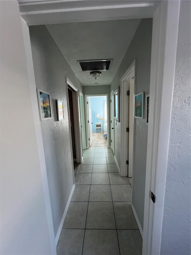 hall featuring light tile patterned flooring