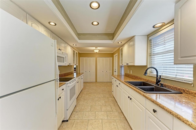 kitchen with sink, white cabinets, a raised ceiling, light stone countertops, and white appliances