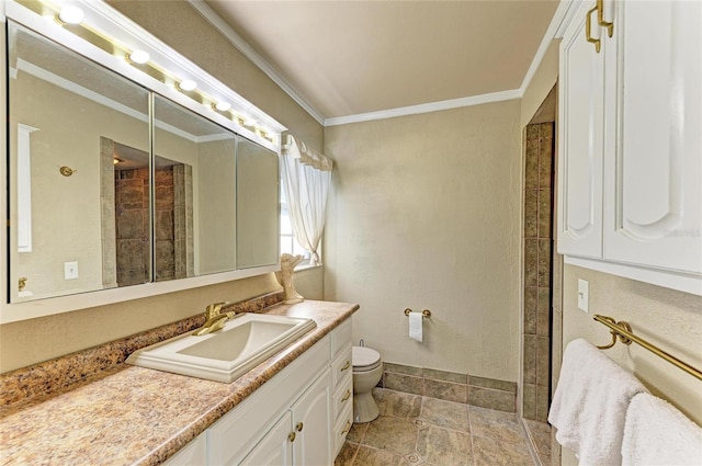 bathroom with ornamental molding, vanity, and toilet