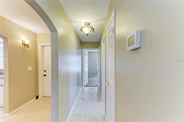 hallway with a textured ceiling