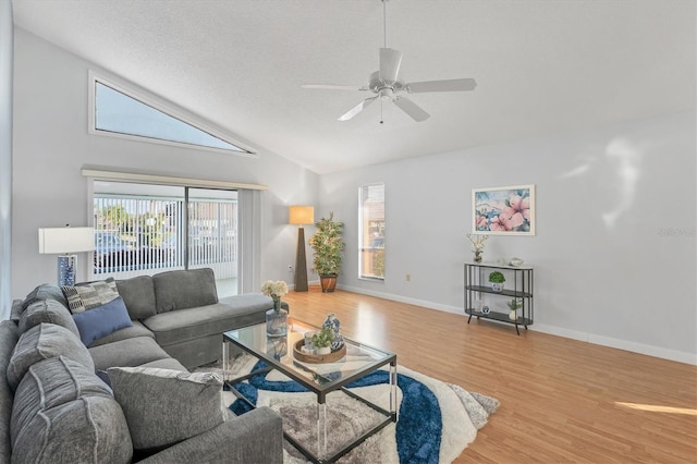 living room featuring hardwood / wood-style flooring, vaulted ceiling, a textured ceiling, and ceiling fan