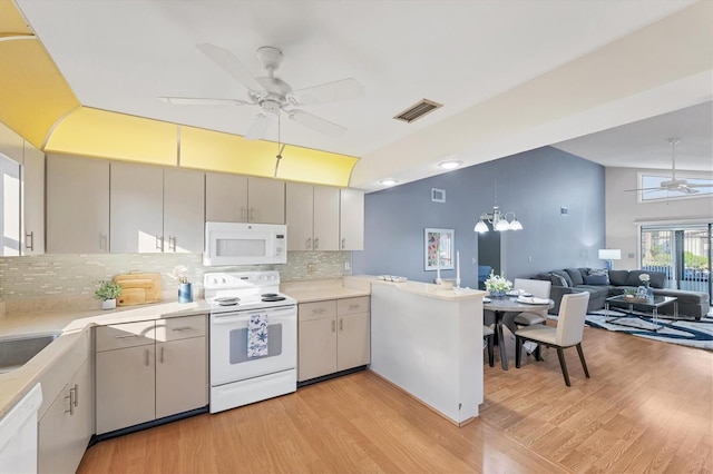 kitchen with vaulted ceiling, light hardwood / wood-style floors, white appliances, and kitchen peninsula