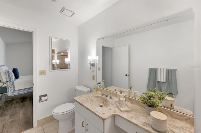 bathroom featuring vanity, toilet, and tile patterned flooring