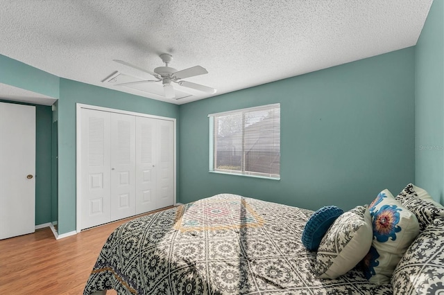 bedroom with ceiling fan, hardwood / wood-style floors, a closet, and a textured ceiling