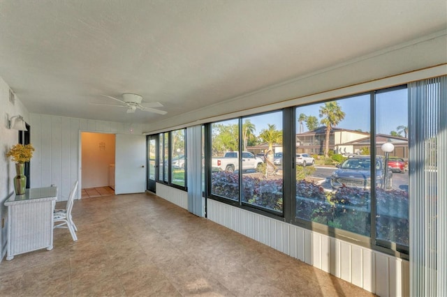 unfurnished sunroom featuring ceiling fan