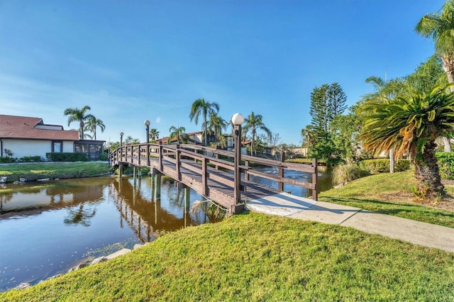 view of dock featuring a water view and a lawn